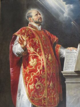 Santo Inácio de Loyola segurando o livro das Constituições da Companhia de Jesus, com o monograma IHS brilhando ao fundo