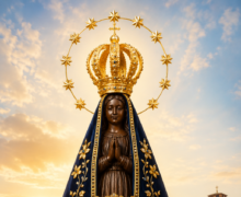 Imagem de Nossa Senhora Aparecida com manto azul bordado em dourado, coroa real e mãos em oração, iluminada por luz celestial ao pôr do sol, com a Basílica de Aparecida ao fundo