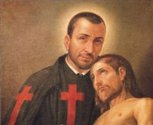 São Camilo de Lellis vestindo batina preta com uma grande cruz vermelha no peito, abraçando e cuidando de um doente em um leito