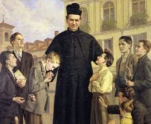 Dom Bosco sorridente, vestindo batina preta e barrete, cercado por um grupo de crianças e jovens de diversas idades